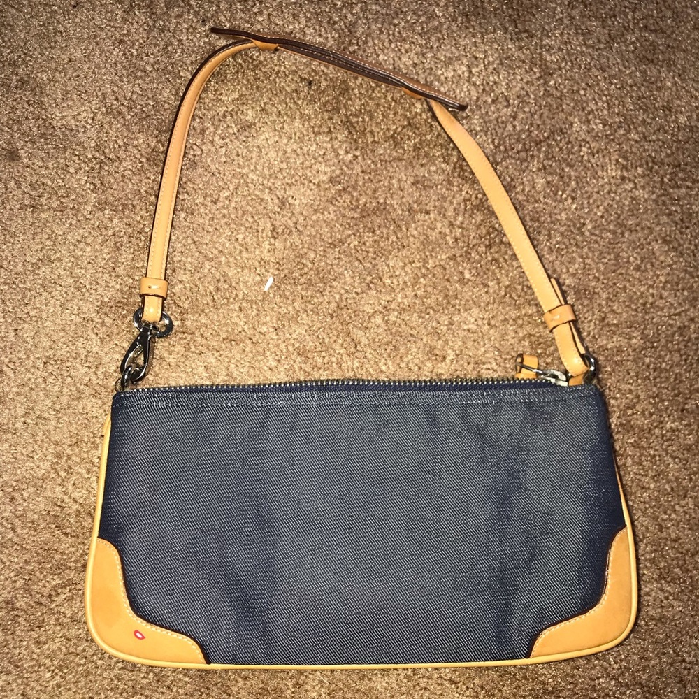 Denim coach bag with tan leather strap.